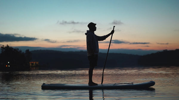 Paddle gonflable sur un lac au coucher du soleil – Nautiya
